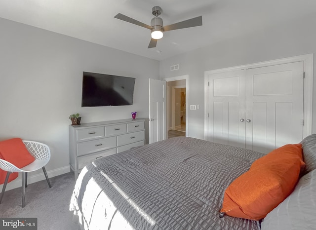 bedroom featuring ceiling fan, baseboards, a closet, and light carpet