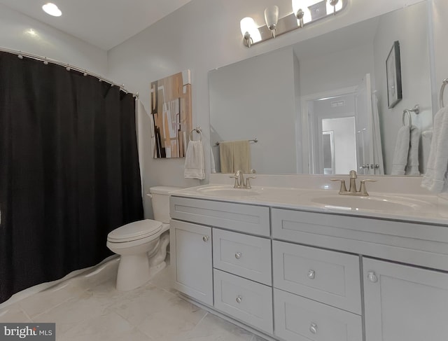 full bathroom featuring double vanity, marble finish floor, toilet, and a sink