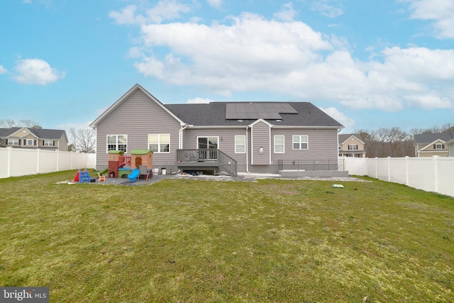 back of property with a yard, a deck, and a fenced backyard