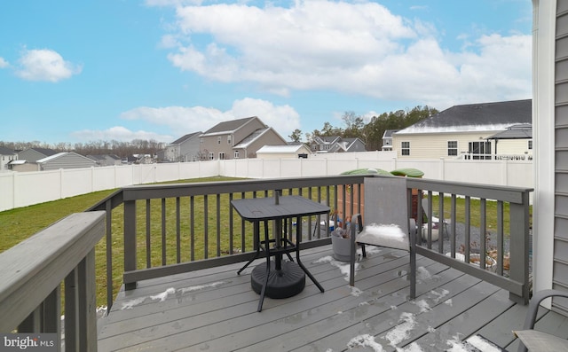 deck featuring a residential view, a lawn, and a fenced backyard