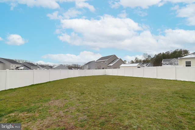 view of yard featuring fence and a residential view