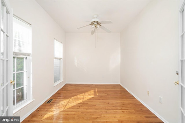 spare room with visible vents, ceiling fan, light wood-type flooring, and baseboards