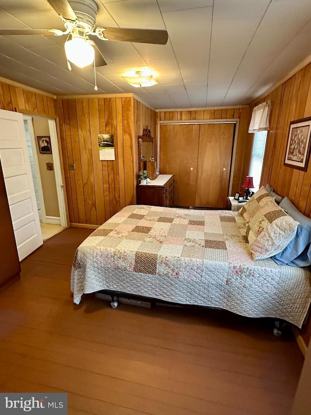 bedroom featuring wooden walls and wood finished floors