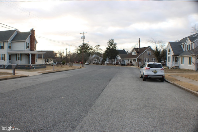 view of street with sidewalks, curbs, and a residential view