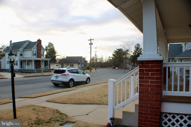 view of road with sidewalks, a residential view, and curbs