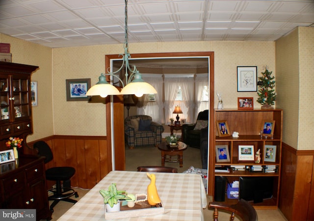 dining area featuring wainscoting and wallpapered walls