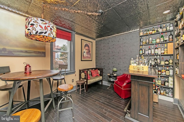 interior space with a dry bar, an ornate ceiling, and baseboards