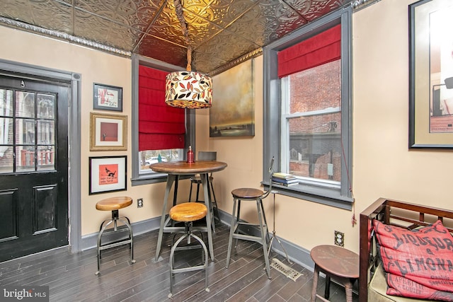 dining space with an ornate ceiling, baseboards, and wood tiled floor