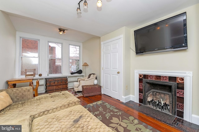 interior space featuring dark wood-type flooring, a fireplace, and baseboards