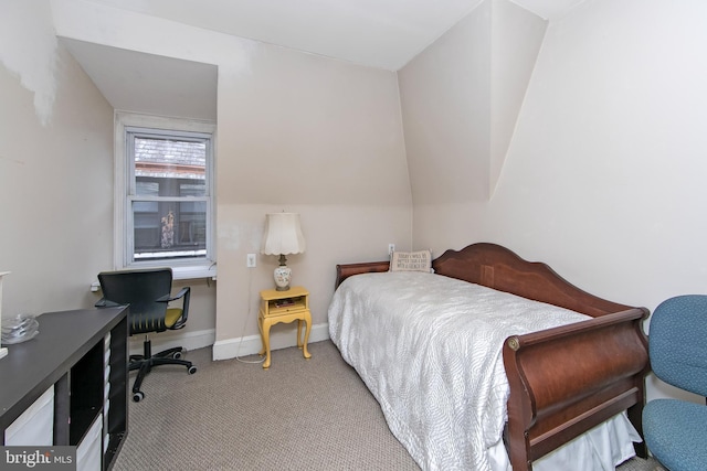 bedroom featuring light carpet, lofted ceiling, and baseboards