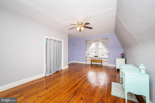 interior space with hardwood / wood-style flooring, a ceiling fan, baseboards, and lofted ceiling