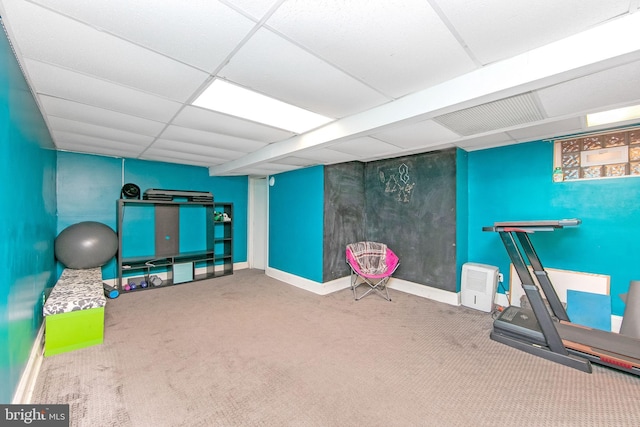 workout room featuring baseboards, a paneled ceiling, and carpet