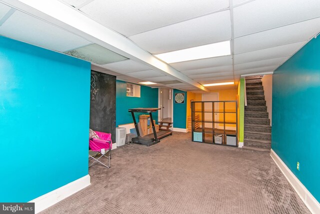 game room with carpet flooring, baseboards, and a drop ceiling