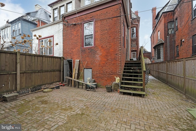 rear view of property with a fenced backyard and brick siding