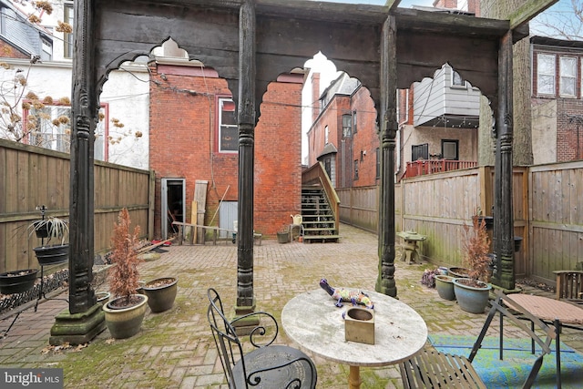 view of patio / terrace featuring a fenced backyard and stairs