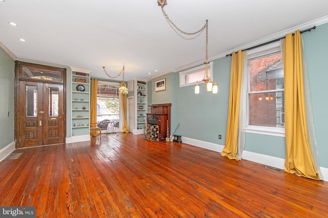 foyer entrance featuring visible vents, baseboards, ornamental molding, and hardwood / wood-style flooring