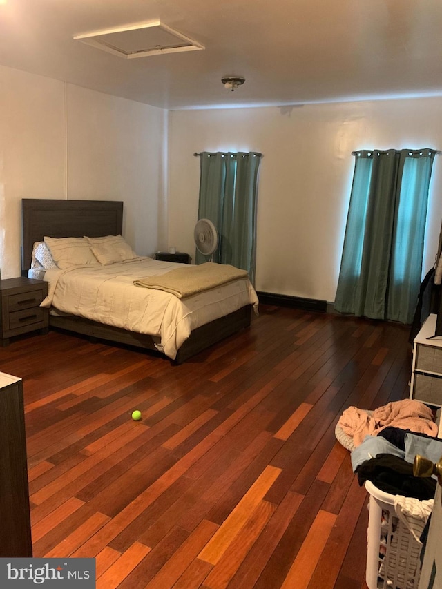 bedroom featuring attic access and dark wood-type flooring