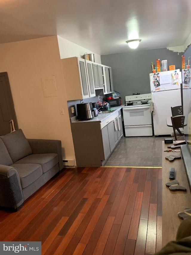 kitchen with white appliances, dark wood-style floors, and light countertops