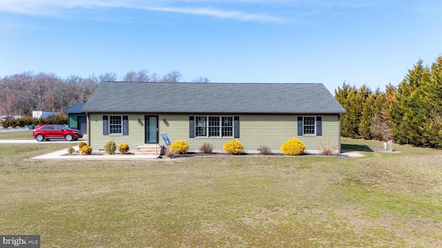 ranch-style house featuring a front yard and roof with shingles