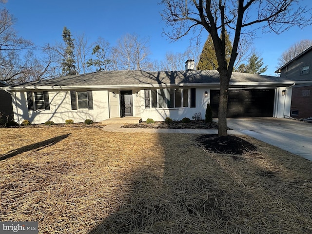 ranch-style home featuring concrete driveway, a chimney, a garage, and roof with shingles