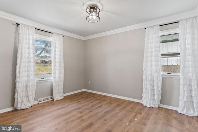 unfurnished room featuring visible vents, baseboards, wood finished floors, and crown molding