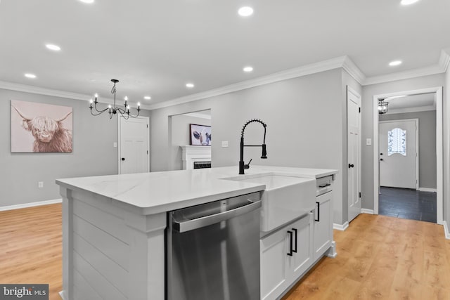 kitchen with a sink, light wood-style floors, an inviting chandelier, and stainless steel dishwasher