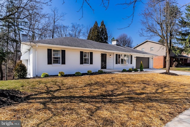 ranch-style home with a front lawn, driveway, a chimney, and a garage