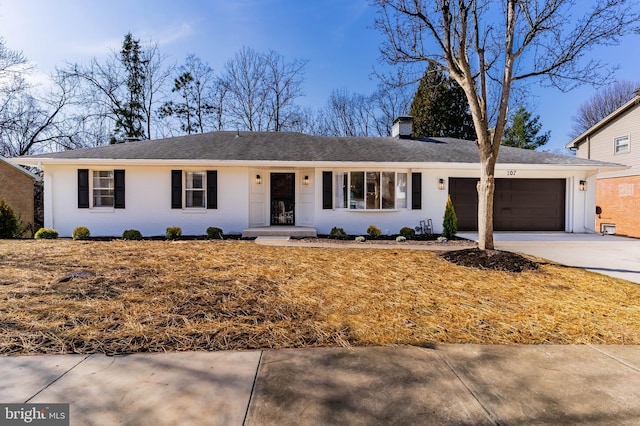 ranch-style house with an attached garage, a chimney, and driveway