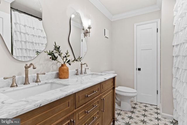 bathroom featuring crown molding, toilet, double vanity, and a sink