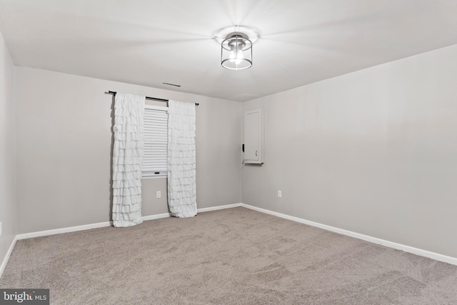 empty room featuring carpet flooring, visible vents, and baseboards