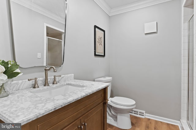 bathroom featuring wood finished floors, a shower with shower door, visible vents, ornamental molding, and toilet