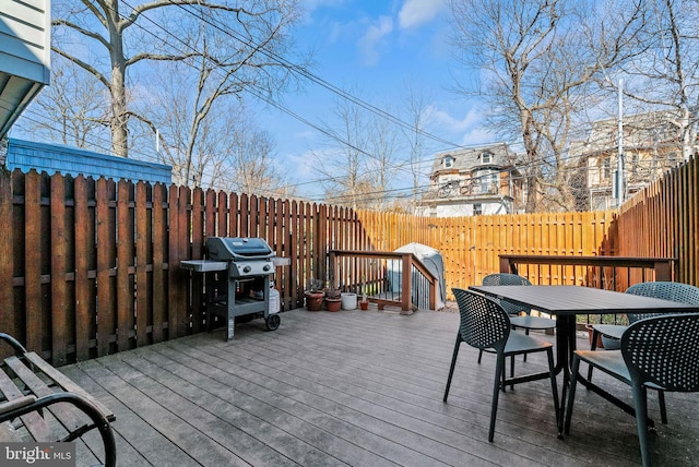 wooden deck featuring outdoor dining area, area for grilling, and fence