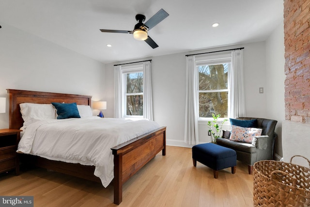 bedroom with multiple windows, baseboards, light wood-type flooring, and ceiling fan