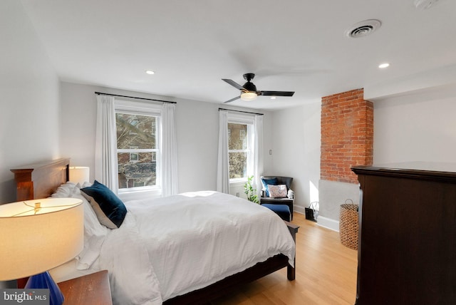 bedroom with recessed lighting, visible vents, baseboards, and wood finished floors