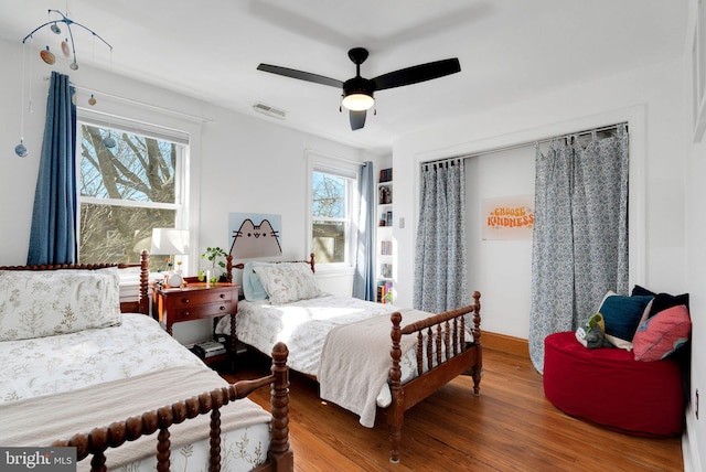 bedroom with visible vents, baseboards, ceiling fan, and wood finished floors