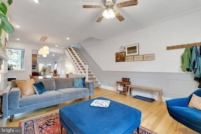 living area featuring wood finished floors, recessed lighting, stairway, wainscoting, and a decorative wall