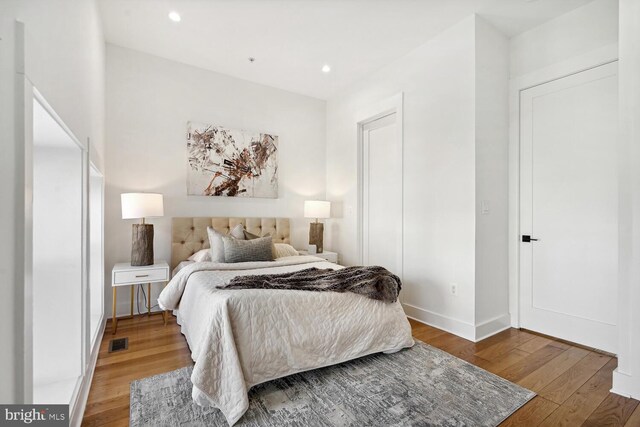 bedroom featuring recessed lighting, visible vents, wood-type flooring, and baseboards