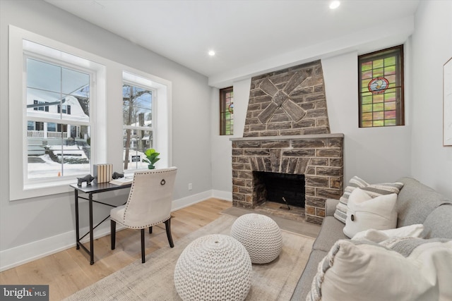 office space with light wood finished floors, recessed lighting, a fireplace, and baseboards