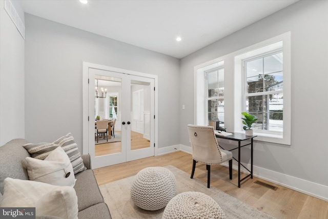 office area featuring plenty of natural light, light wood-style flooring, french doors, and baseboards