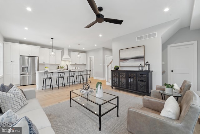 living room featuring light wood-type flooring, visible vents, and recessed lighting