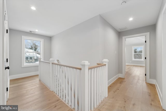 hall featuring visible vents, baseboards, an upstairs landing, light wood-style flooring, and recessed lighting