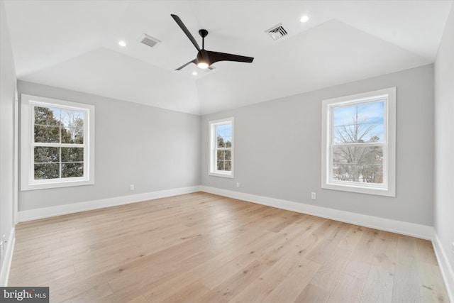 empty room with visible vents, baseboards, light wood-style floors, and vaulted ceiling