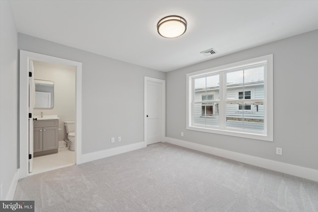 unfurnished bedroom with baseboards, visible vents, and light carpet