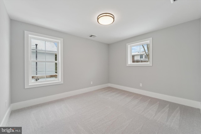 unfurnished room featuring visible vents, plenty of natural light, baseboards, and carpet flooring