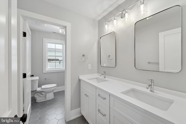 full bath with tile patterned flooring, double vanity, toilet, and a sink