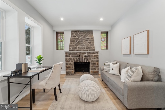 living room with recessed lighting, light wood-style flooring, and a fireplace