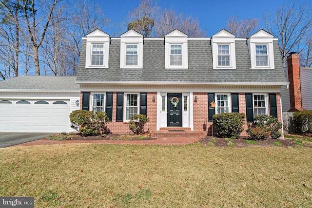 view of front of home with aphalt driveway, brick siding, roof with shingles, and a front lawn