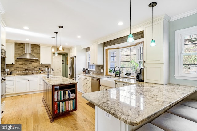 kitchen featuring open shelves, ornamental molding, stainless steel appliances, wall chimney range hood, and light wood-type flooring