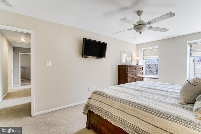 bedroom featuring light colored carpet, baseboards, and ceiling fan