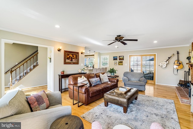 living room featuring stairway, baseboards, light wood finished floors, recessed lighting, and ornamental molding